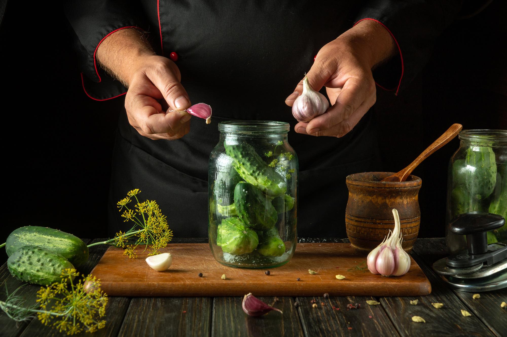 Studio chef arranging herbs over a batch of preserves